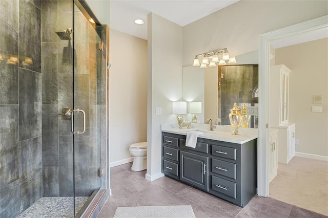 bathroom featuring baseboards, toilet, tile patterned floors, vanity, and a shower stall