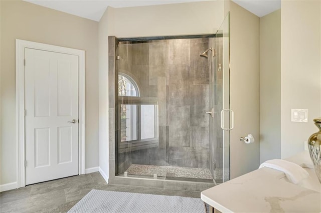 full bathroom featuring a shower stall and baseboards