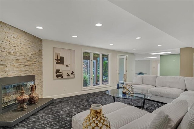 living room featuring carpet floors, recessed lighting, a fireplace, and baseboards