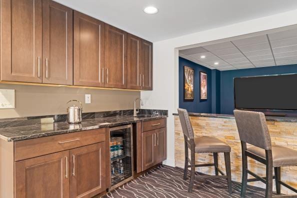 bar featuring beverage cooler, wet bar, a sink, and recessed lighting