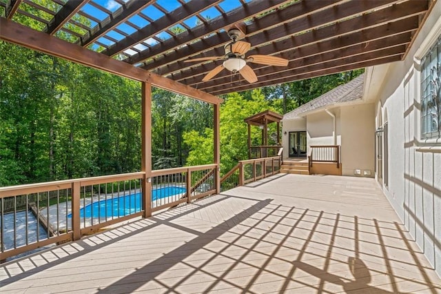 wooden terrace featuring french doors, a patio, a ceiling fan, a pergola, and an outdoor pool