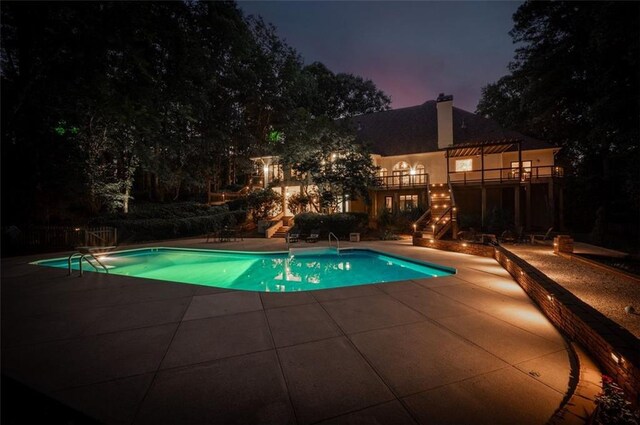 pool with stairs, a patio area, and a pergola