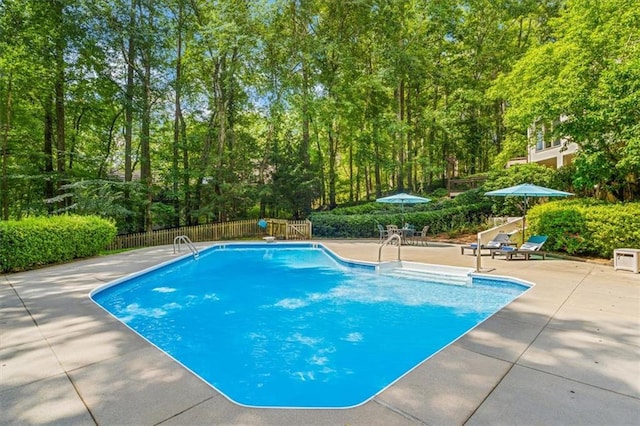 view of swimming pool with a patio area, fence, and a fenced in pool