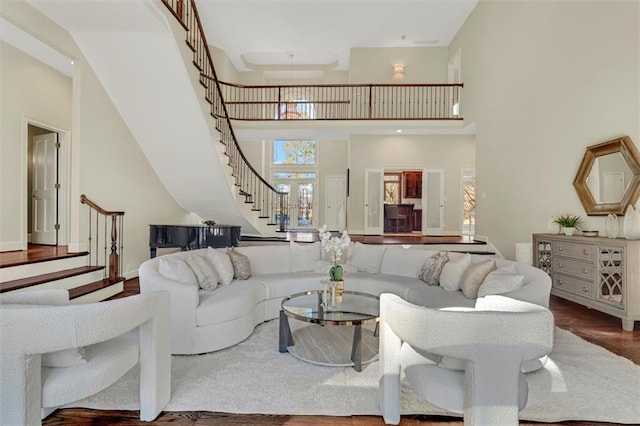 living room featuring stairs, a high ceiling, and wood finished floors