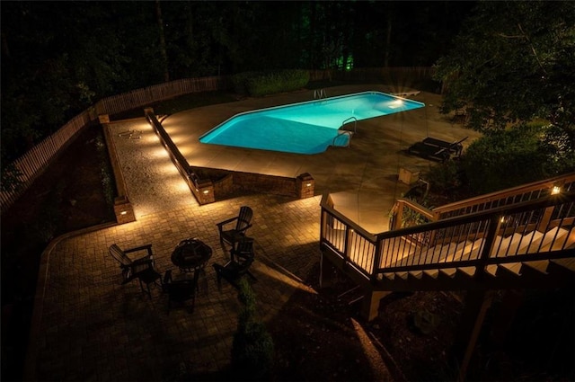 outdoor pool with a fenced backyard, a deck, and a patio