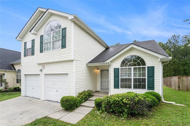 view of front of house featuring a front lawn, driveway, an attached garage, and fence