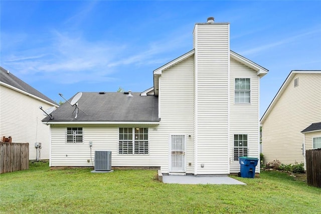 back of house with a yard, fence, central air condition unit, and a chimney