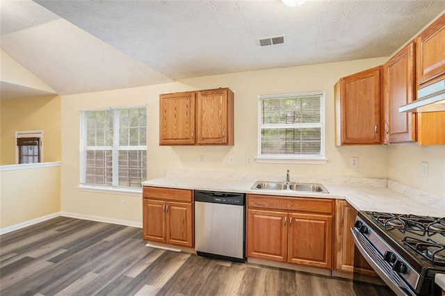 kitchen featuring stainless steel dishwasher, visible vents, a sink, dark wood-type flooring, and light countertops