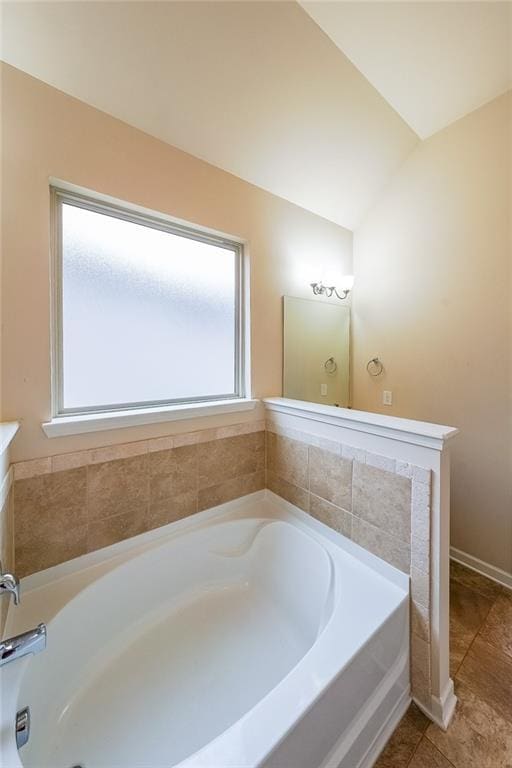 bathroom with lofted ceiling, a bath, and vanity