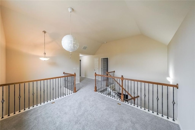 hallway with vaulted ceiling and carpet