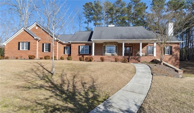 ranch-style home featuring a front lawn, a porch, brick siding, and a chimney