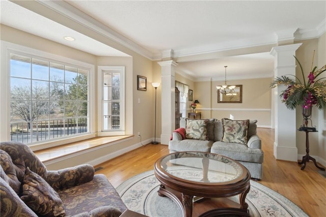 living room with crown molding, baseboards, light wood-type flooring, and ornate columns