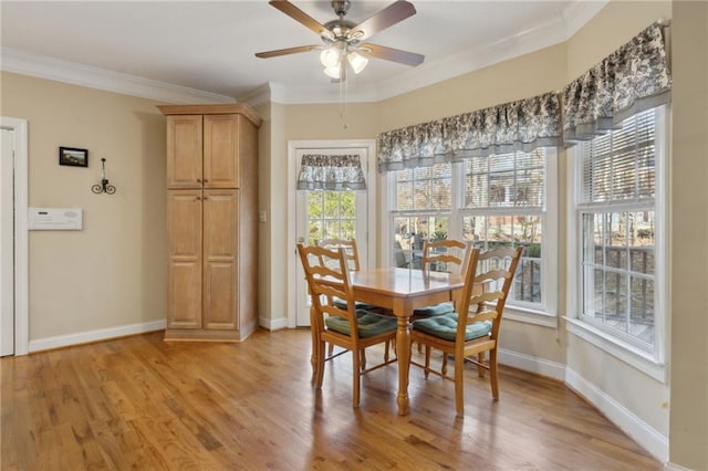 dining area with baseboards, crown molding, and light wood finished floors