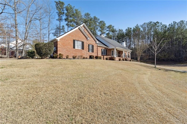 single story home with a front yard, covered porch, brick siding, and roof mounted solar panels