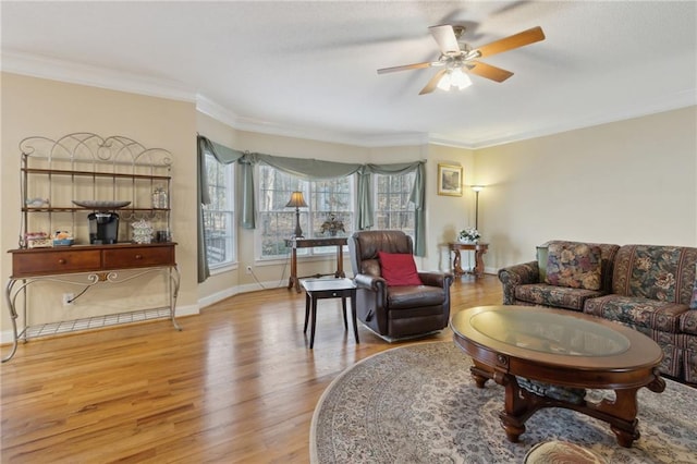 living room with baseboards, wood finished floors, a ceiling fan, and ornamental molding