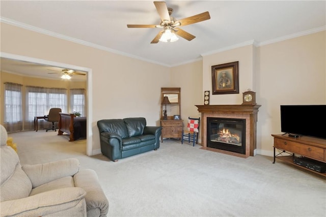 living room with ceiling fan, a fireplace with flush hearth, carpet floors, and ornamental molding