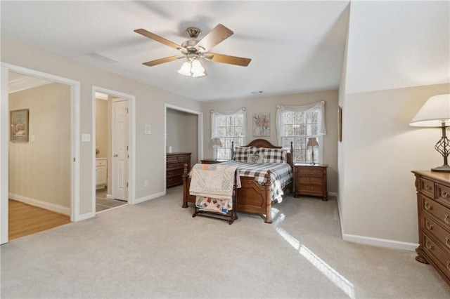 bedroom featuring a ceiling fan, visible vents, baseboards, ensuite bath, and light colored carpet