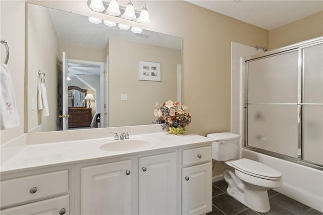 bathroom featuring vanity, tile patterned floors, toilet, and enclosed tub / shower combo