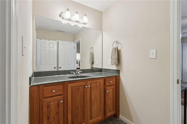 bathroom featuring visible vents, baseboards, and vanity