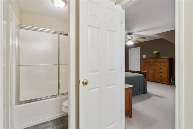 full bath with bath / shower combo with glass door, toilet, a textured ceiling, ensuite bath, and a ceiling fan