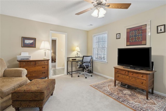 carpeted office space featuring visible vents, a ceiling fan, and baseboards