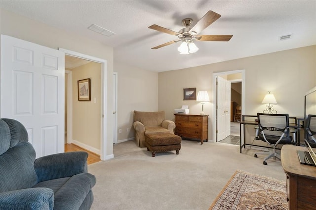 office space featuring ceiling fan, baseboards, visible vents, and light carpet