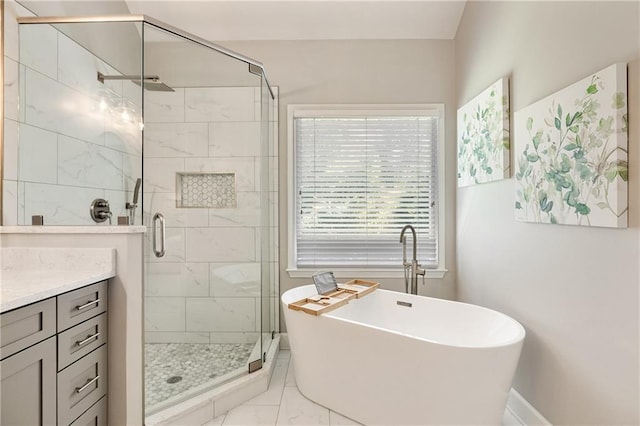 full bathroom with marble finish flooring, a freestanding tub, a shower stall, and vanity