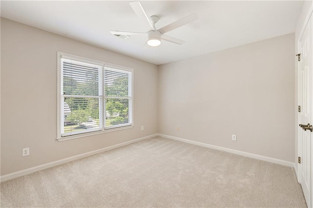 unfurnished room featuring light carpet, baseboards, and a ceiling fan