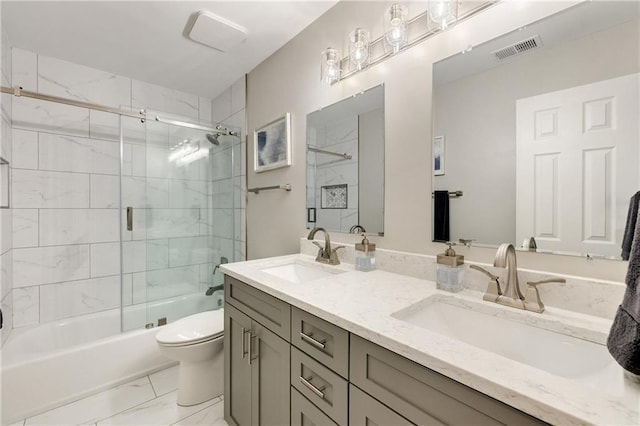 bathroom with marble finish floors, toilet, shower / bath combination with glass door, and double vanity