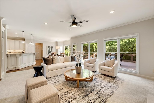 living area with ornamental molding, ceiling fan, recessed lighting, baseboards, and light carpet