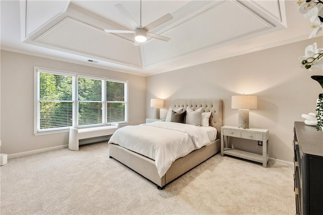 bedroom featuring light colored carpet, crown molding, baseboards, ceiling fan, and a tray ceiling