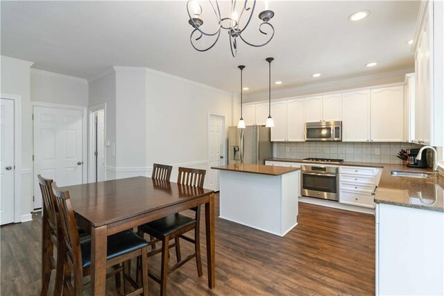 5073 Kingsbridge Pass, Powder Springs, GA 30127 - kitchen featuring tasteful backsplash, a sink, appliances with stainless steel finishes, dark wood-style floors, and a kitchen island