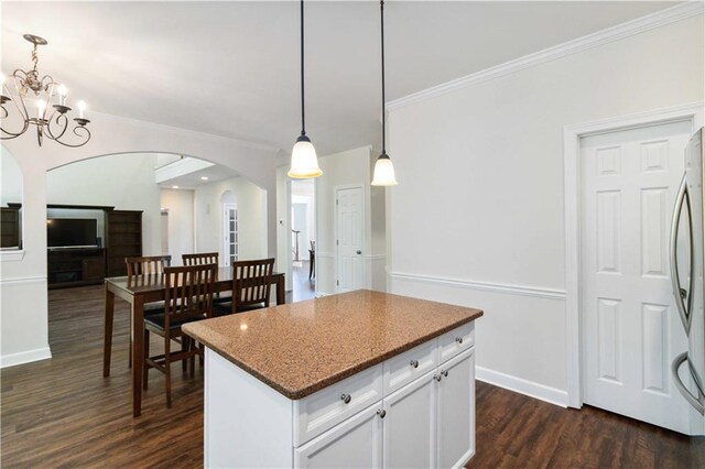 5073 Kingsbridge Pass, Powder Springs, GA 30127 - kitchen with arched walkways, hanging light fixtures, dark wood-style floors, and white cabinetry