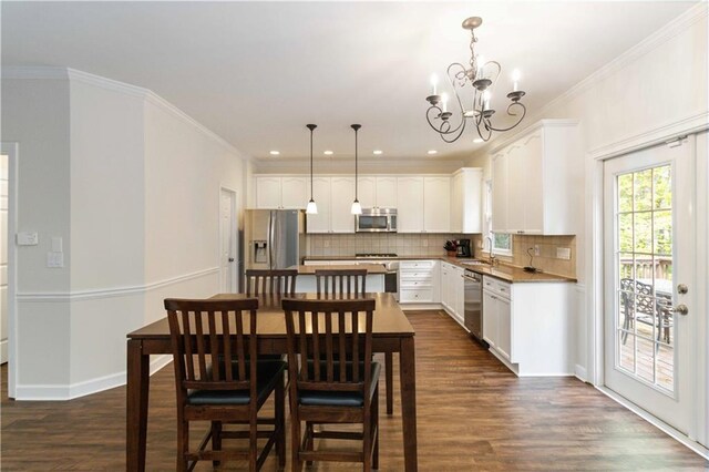 5073 Kingsbridge Pass, Powder Springs, GA 30127 - dining space with crown molding, an inviting chandelier, baseboards, dark wood-style floors, and recessed lighting