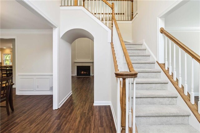 5073 Kingsbridge Pass, Powder Springs, GA 30127 - staircase with a towering ceiling, crown molding, a lit fireplace, and wood finished floors