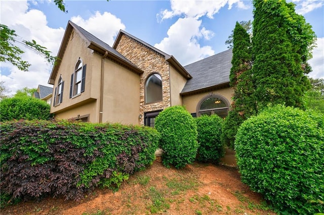 view of front of house featuring stucco siding and stone siding