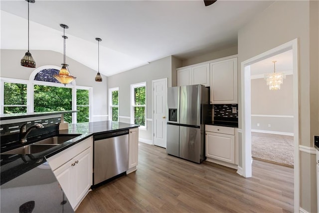 kitchen featuring white cabinets, dark countertops, appliances with stainless steel finishes, and a sink
