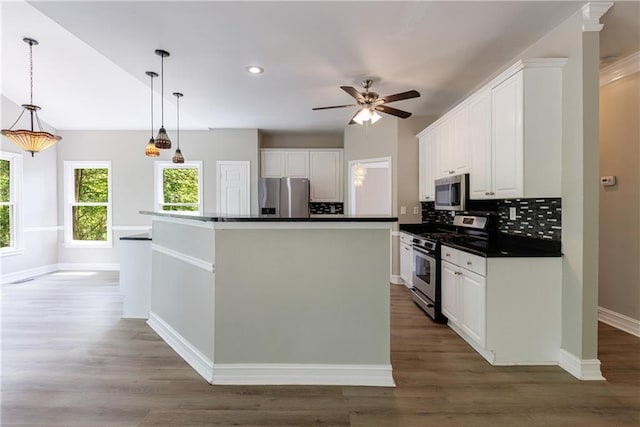 kitchen featuring white cabinetry, tasteful backsplash, dark countertops, and appliances with stainless steel finishes