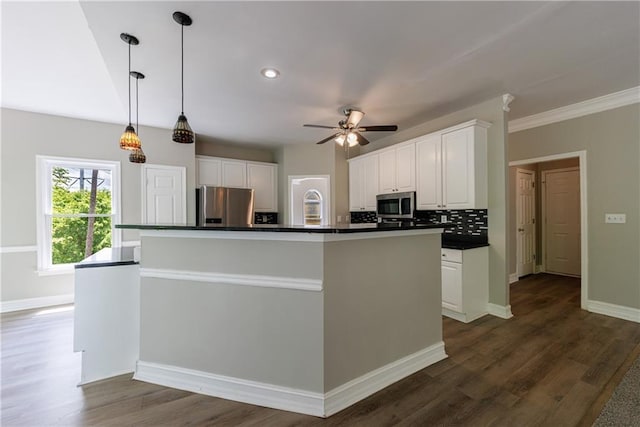 kitchen featuring white cabinetry, dark countertops, stainless steel appliances, dark wood finished floors, and a center island with sink