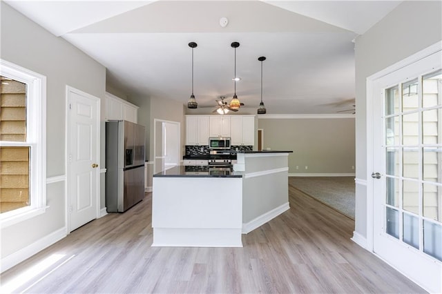 kitchen with appliances with stainless steel finishes, white cabinets, dark countertops, baseboards, and a ceiling fan