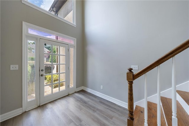 entrance foyer with wood finished floors, baseboards, and stairs