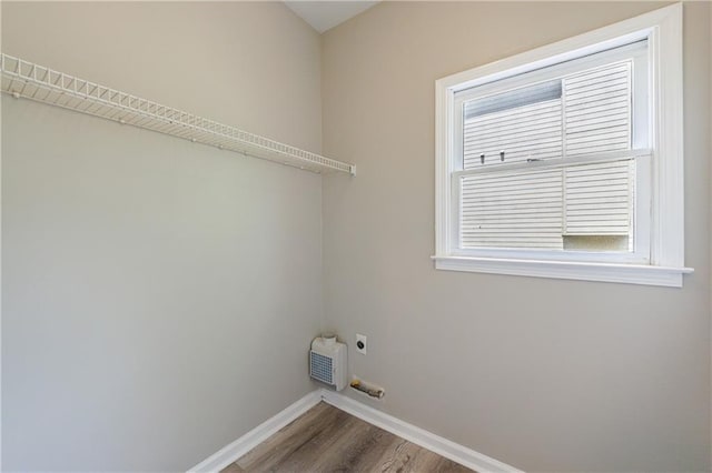 laundry area with hookup for an electric dryer, wood finished floors, laundry area, and baseboards