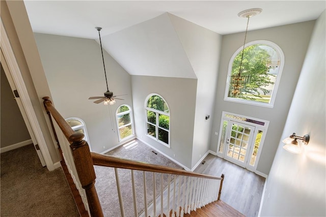 staircase featuring high vaulted ceiling, ceiling fan, wood finished floors, and baseboards