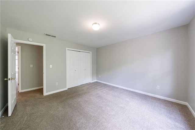 unfurnished bedroom with carpet flooring, a closet, visible vents, and baseboards