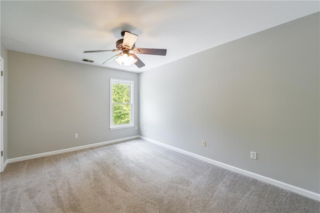spare room featuring visible vents, a ceiling fan, carpet flooring, and baseboards