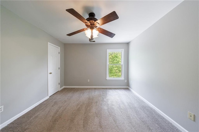 empty room with a ceiling fan, carpet flooring, and baseboards