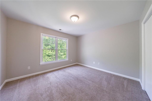 spare room with visible vents, carpet flooring, and baseboards