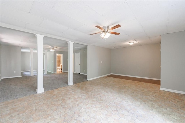 finished basement featuring stone finish flooring, a ceiling fan, and baseboards