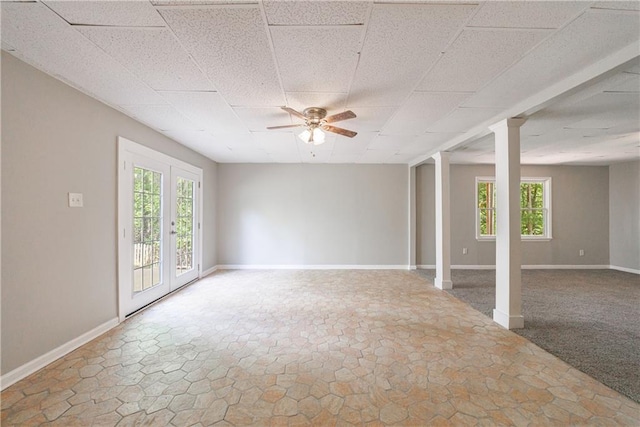 unfurnished room with a wealth of natural light, a drop ceiling, and ceiling fan