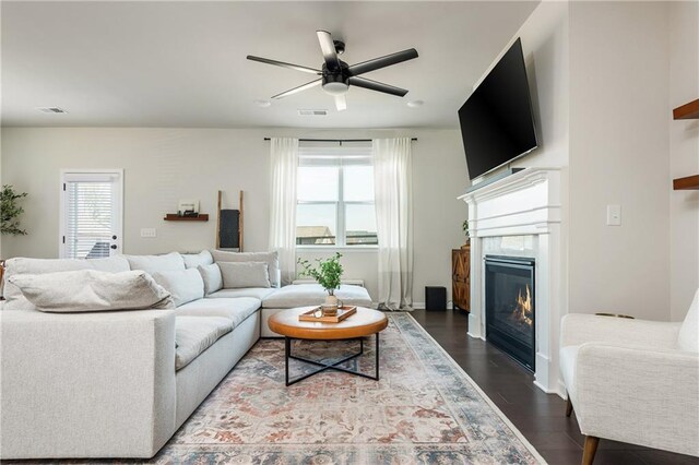 5025 Bryce Ln, Cumming, GA 30040 - living room featuring ceiling fan, dark wood-style floors, a glass covered fireplace, and baseboards